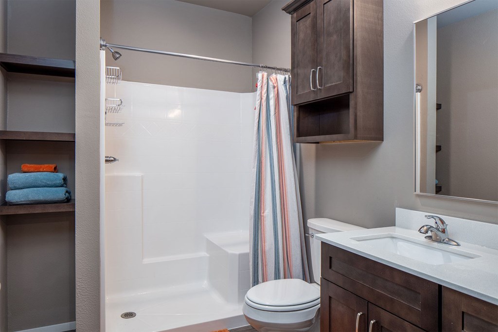 A bathroom with a toilet, sink, and shower.