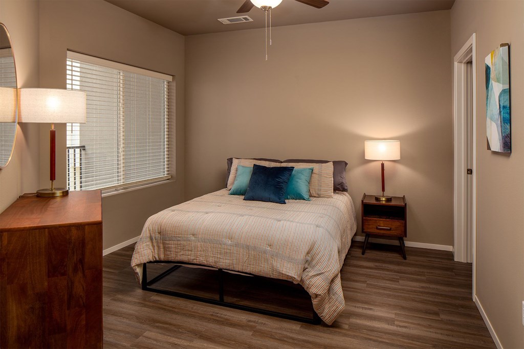 A bedroom with a bed, nightstands, and a ceiling fan.