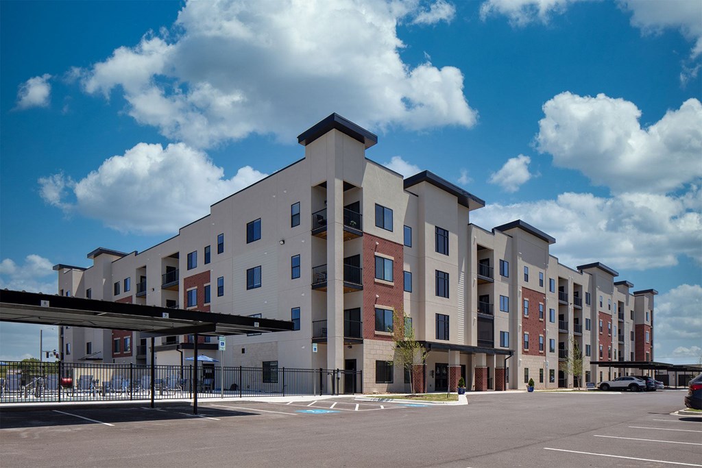 A large apartment complex with a parking lot in front.