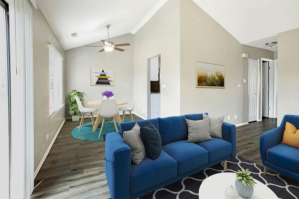 a living room with a blue couch and a dining room table