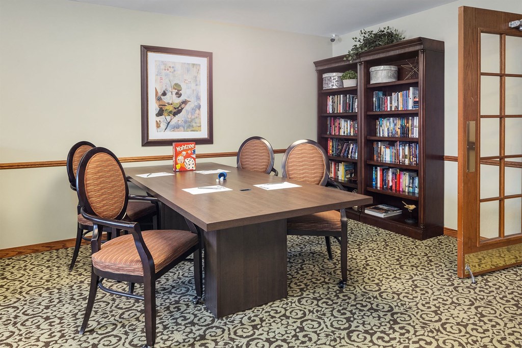 a meeting room with a table and chairs and a bookcase