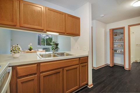 a kitchen with a sink and wooden cabinets      and a door