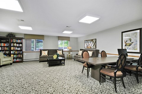 a living room with a table and chairs and a library