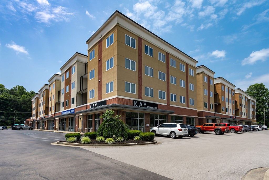 A large hotel with a parking lot in front of it.