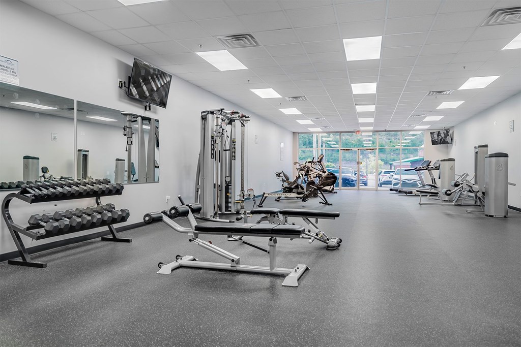 A gym with a variety of equipment including weights and machines.