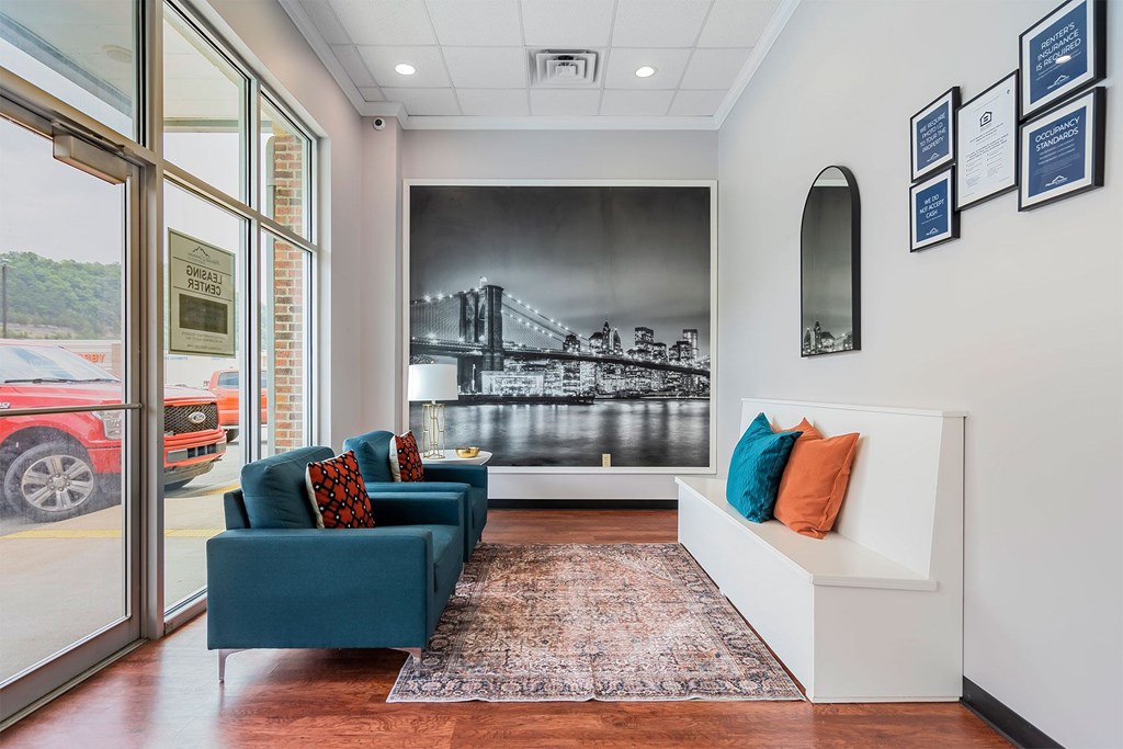 A living room with a couch, chairs, and a large bridge mural on the wall.