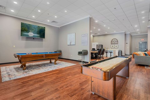 A room with a pool table and a foosball table.