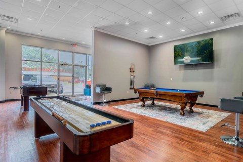 A room with a pool table and a billiard table.