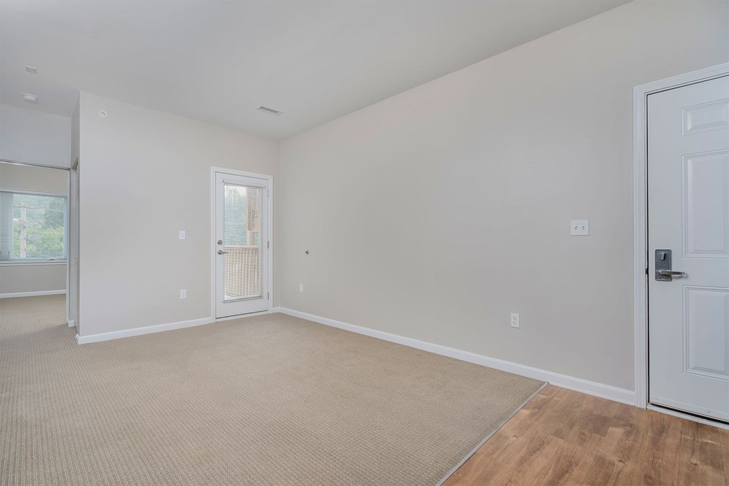 A room with a door, window, and carpeted floor.