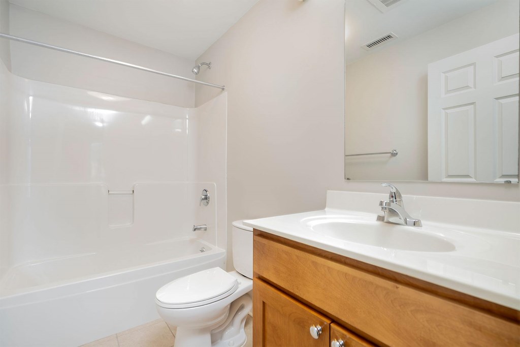 A white toilet sits next to a white sink in a bathroom.