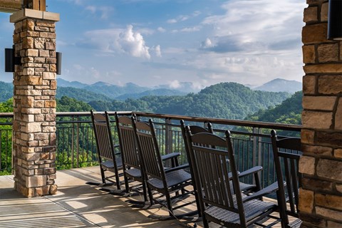 A balcony with chairs and a view of the mountains.