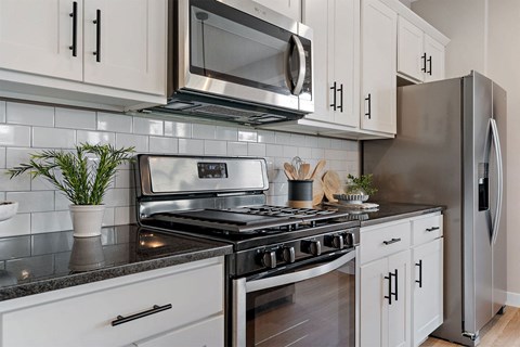 a kitchen with stainless steel appliances and white cabinets