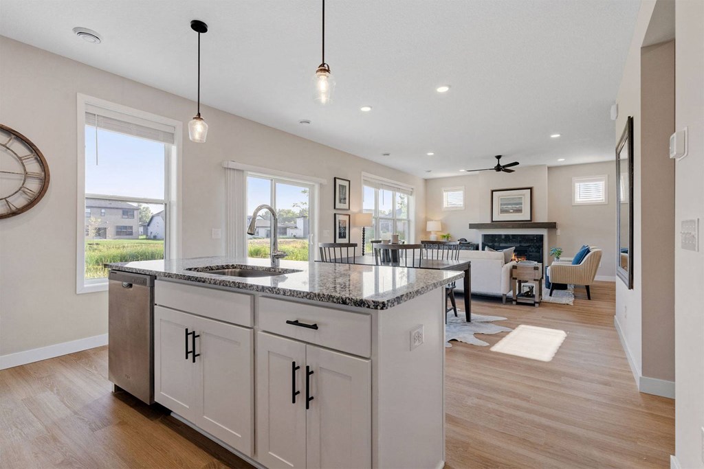 a kitchen with an island and a living room with a fireplace