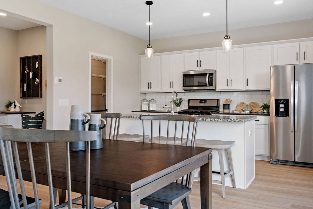 a kitchen and dining room with a table and chairs
