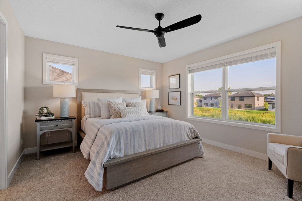 a bedroom with a bed and a ceiling fan
