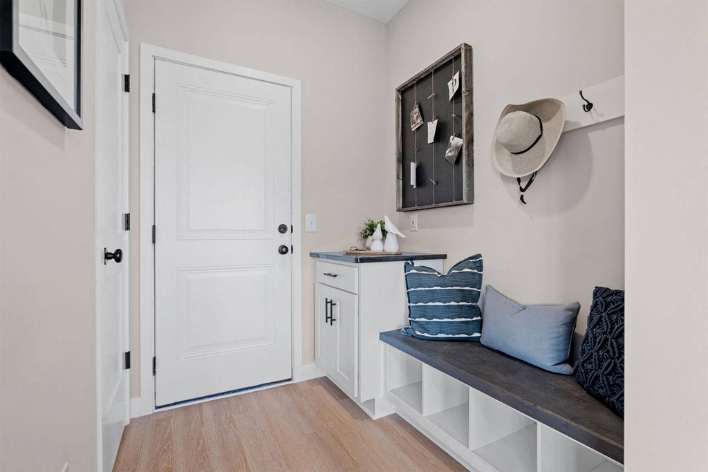 a living room with a bench and a white door