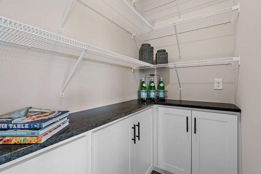 a laundry room with white cabinets and a counter top