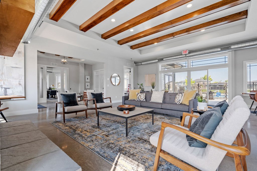 a living room with a couch and chairs and a large window