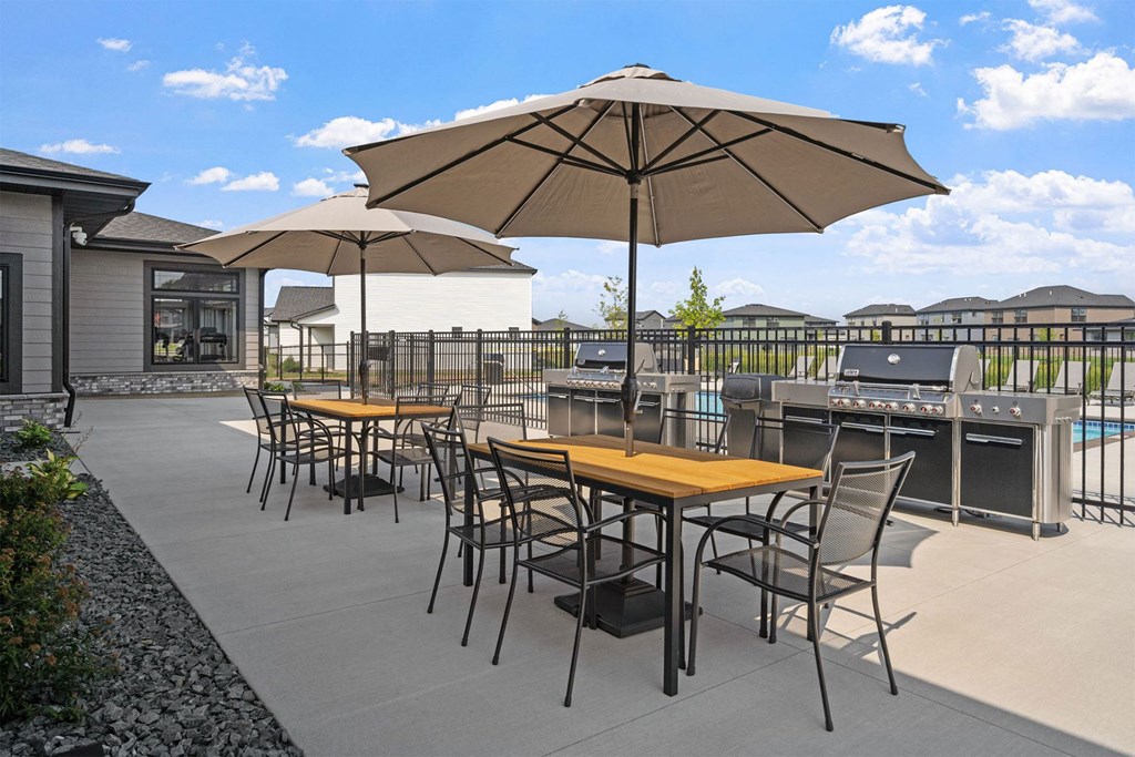 a patio with tables and chairs and umbrellas
