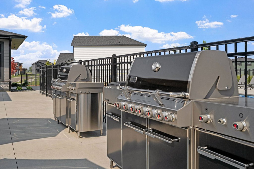 two stainless steel barbecue grills on a patio