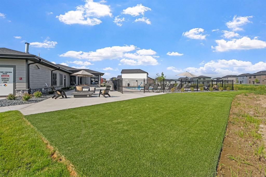 the backyard of a home with a playground and a grass field