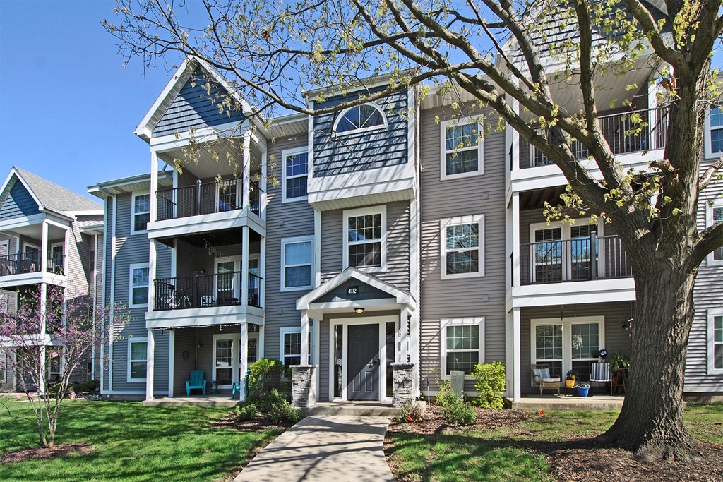 an apartment building with a tree in front of it