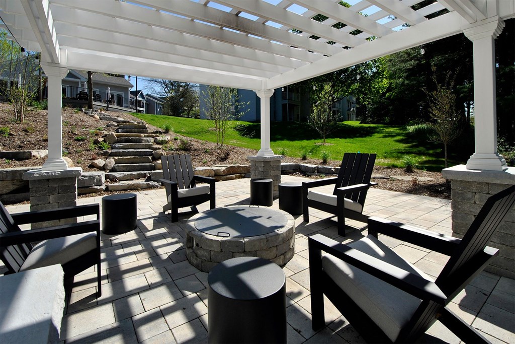 a covered patio with chairs and a fire pit