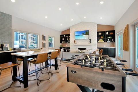 a game room with a foosball table and a bar