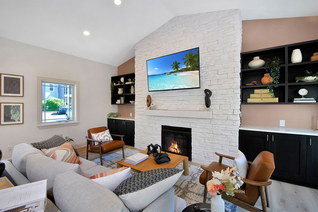 the living room has a fireplace and a tv above it