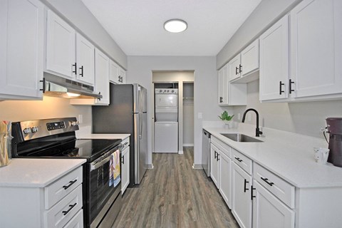 a kitchen with white cabinets and stainless steel appliances
