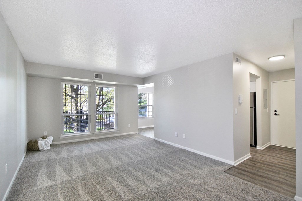 the living room and dining room of an empty house with a large window