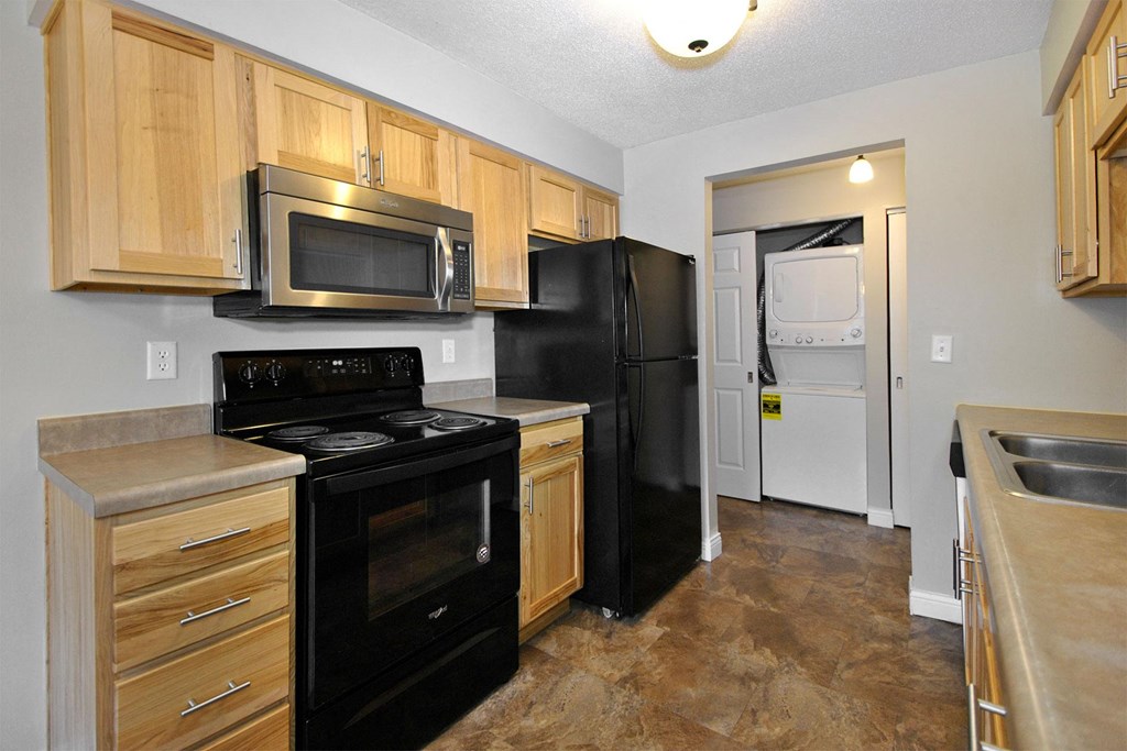 a kitchen with black appliances and wooden cabinets