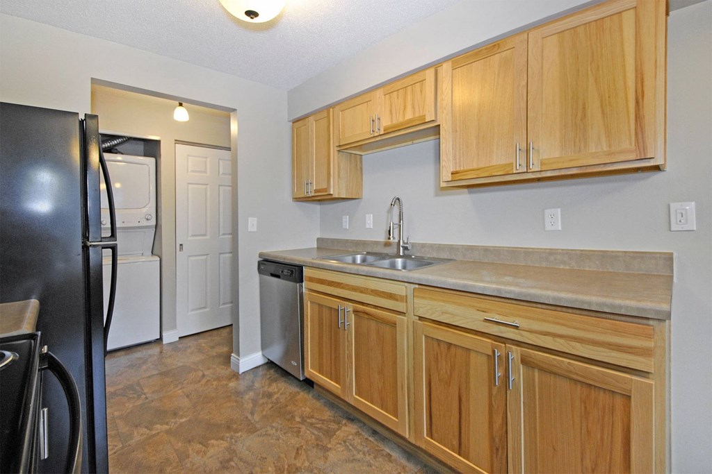 a kitchen with wooden cabinets and a sink and a refrigerator