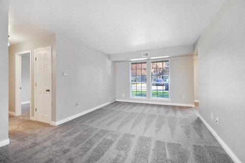 the living room of an empty house with a large window