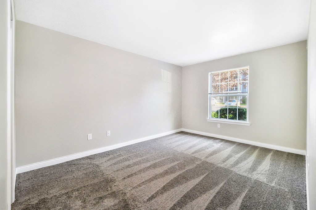 an empty room with carpet and a window