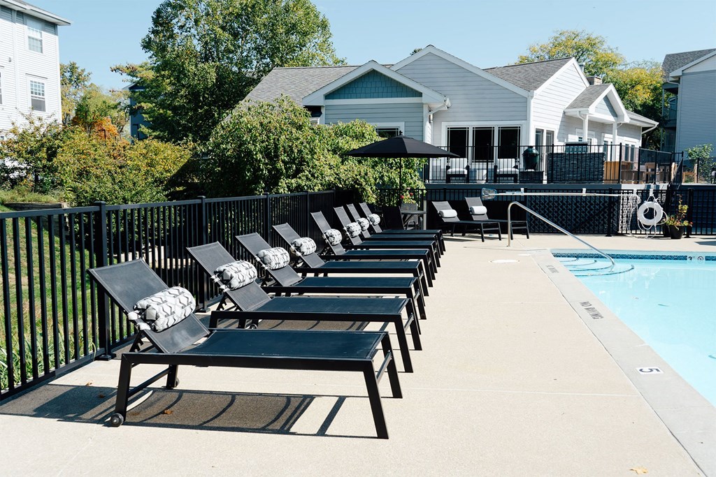a row of lounge chairs next to a pool