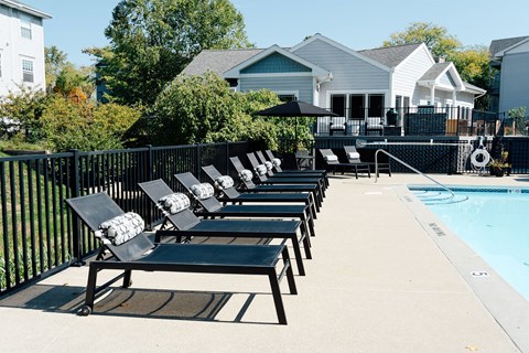 a row of lounge chairs next to a pool