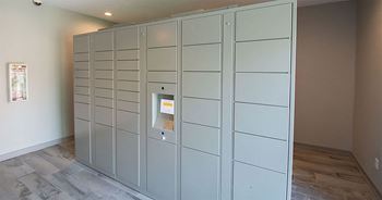 a row of white lockers in a room with a wood floor