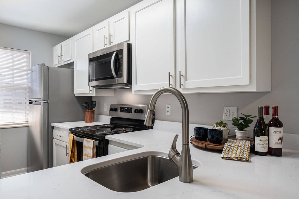 a kitchen with stainless steel appliances and white cabinets