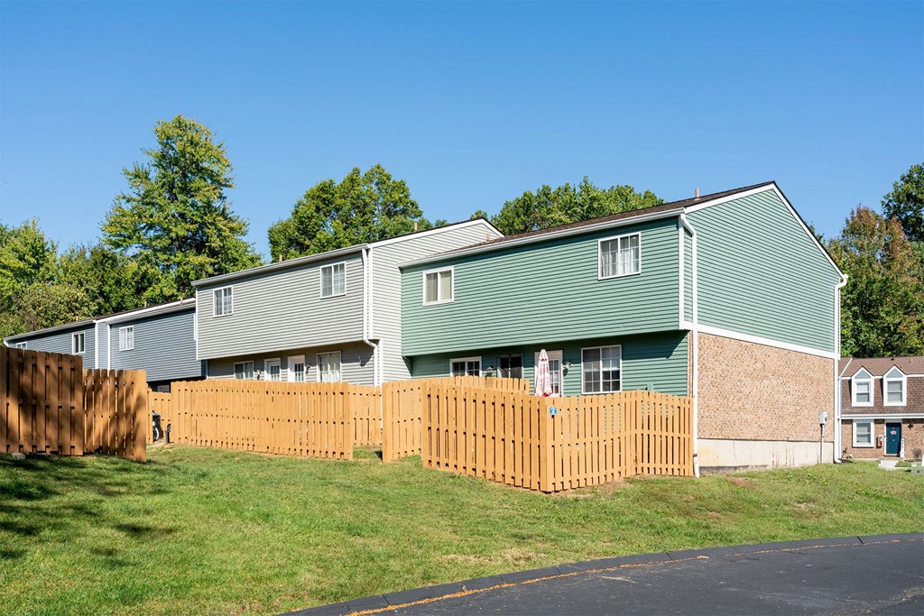 a wooden fence in front of a green house