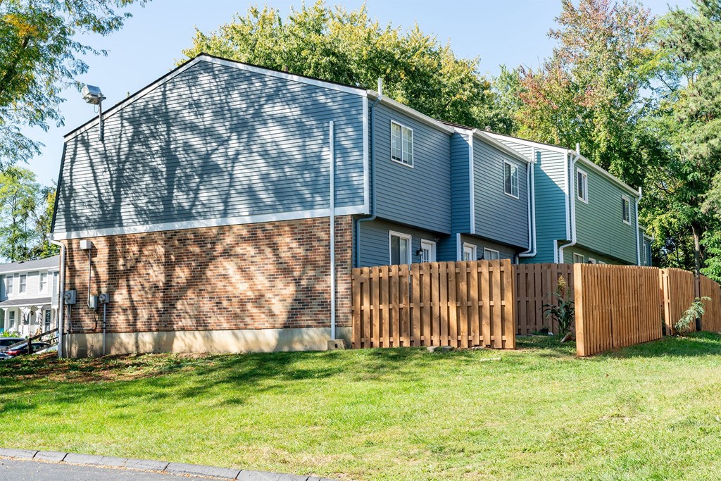 blue townhome with a wooden fence in the back