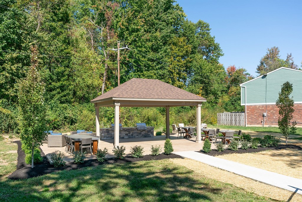 a pavilion with a table and chairs in a yard