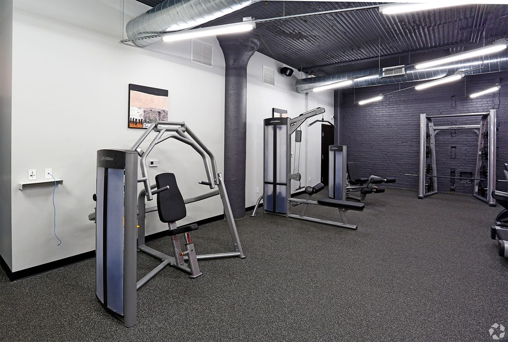 A gym with a variety of equipment including a leg press machine.