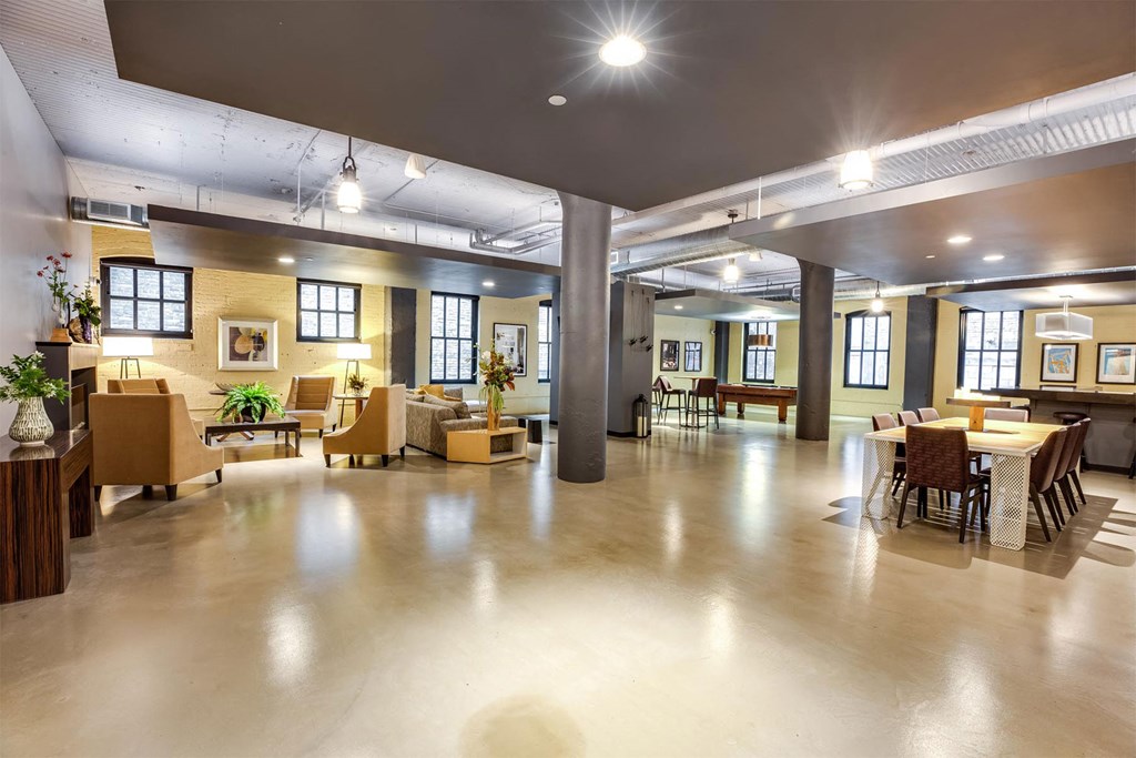 A spacious room with a high ceiling and a mix of modern and vintage furniture.