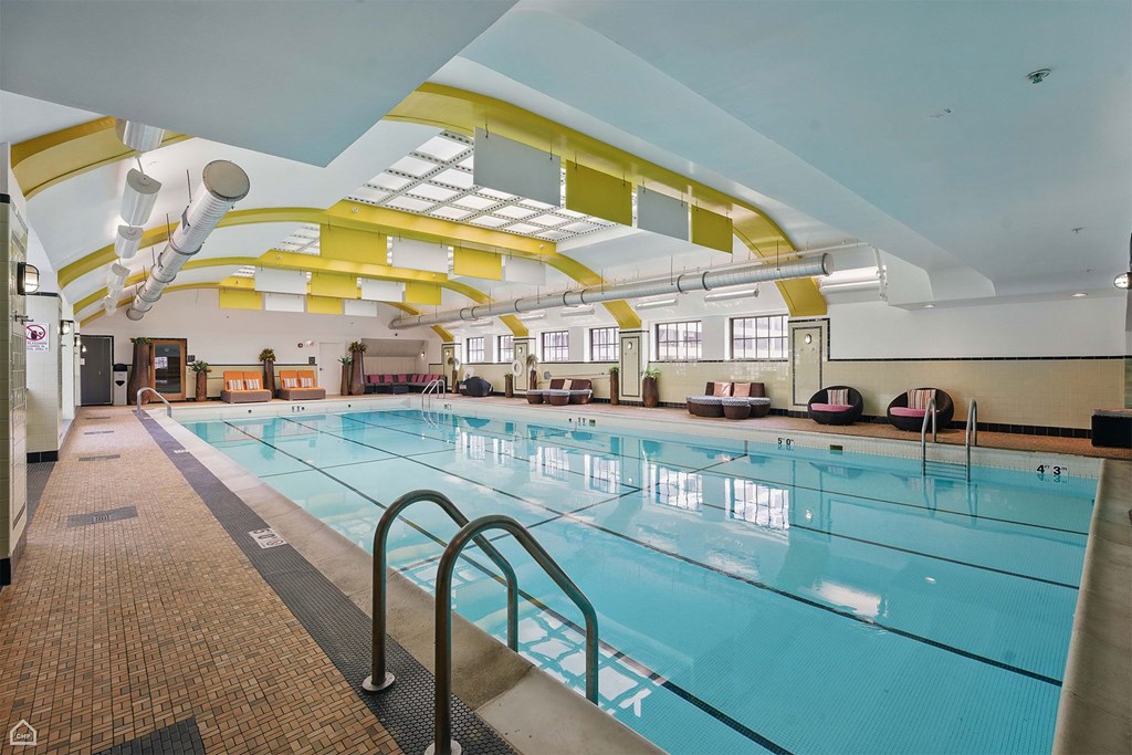 A large indoor swimming pool with a yellow and white ceiling.