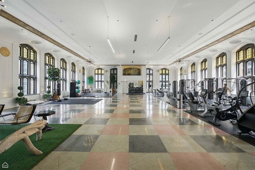 A gym with a variety of equipment and a green rug on the floor.