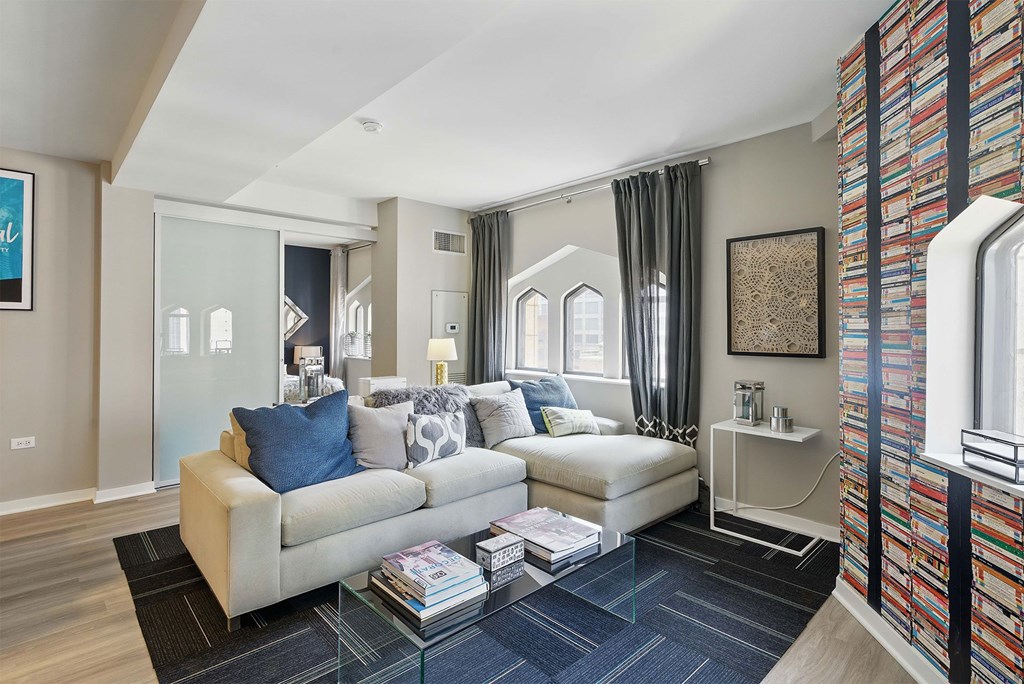 A living room with a white couch and a glass coffee table.