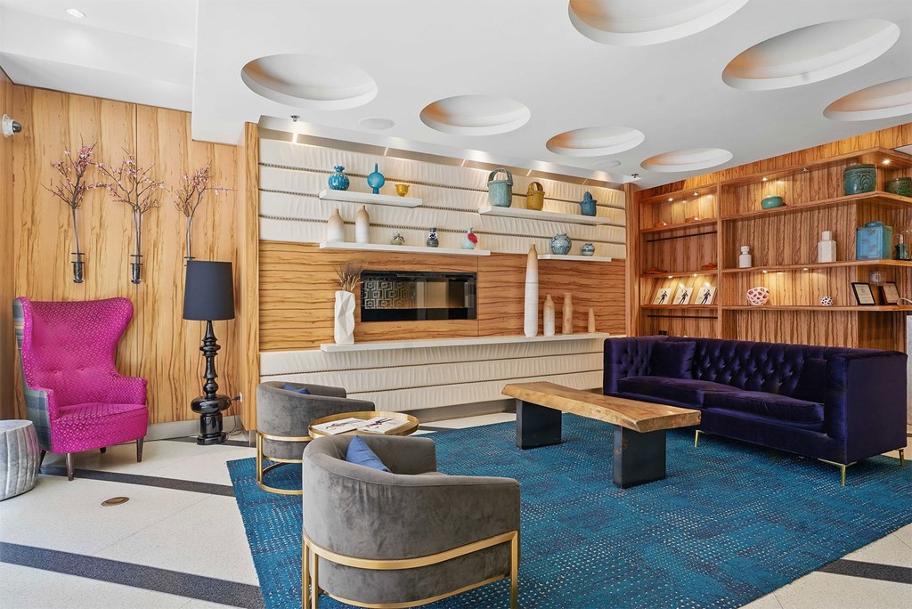 A living room with a pink chair and a purple couch.