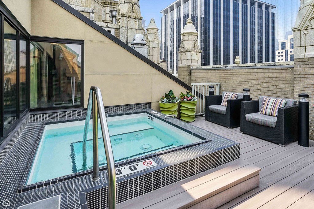 A hot tub on a balcony with a view of a cityscape.