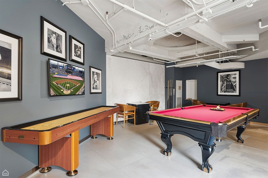 A pool table with a red cloth and a pool cue on it.